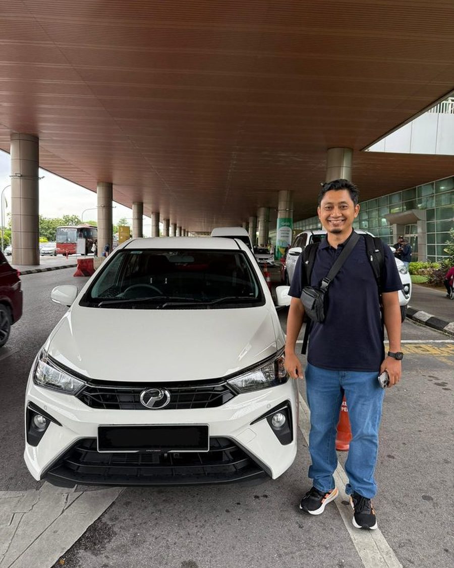 Car&Go customer with a white Perodua rental car at Kuching International Airport